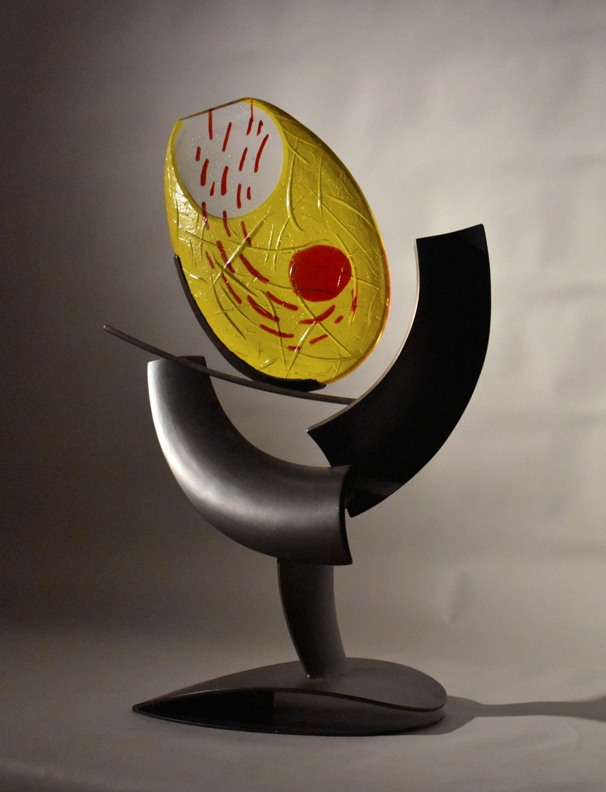 Abstract sculpture with metal and oval red and yellow cast glass